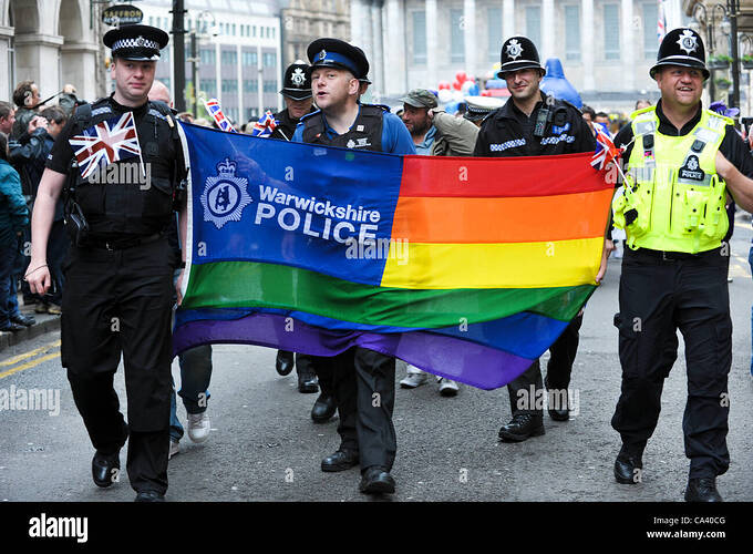 warwickshire-police-officers-with-a-gay-rainbow-flag-marching-to-celebrate-CA40CG